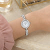 Montre femme OLEVS Brigitte argentée portée au poignet, bracelet en acier et zirconium