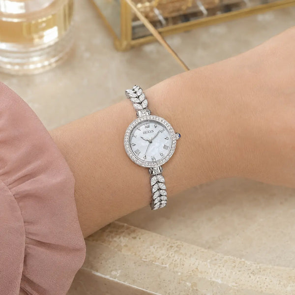 Montre femme OLEVS Brigitte argentée portée au poignet, bracelet en acier et zirconium