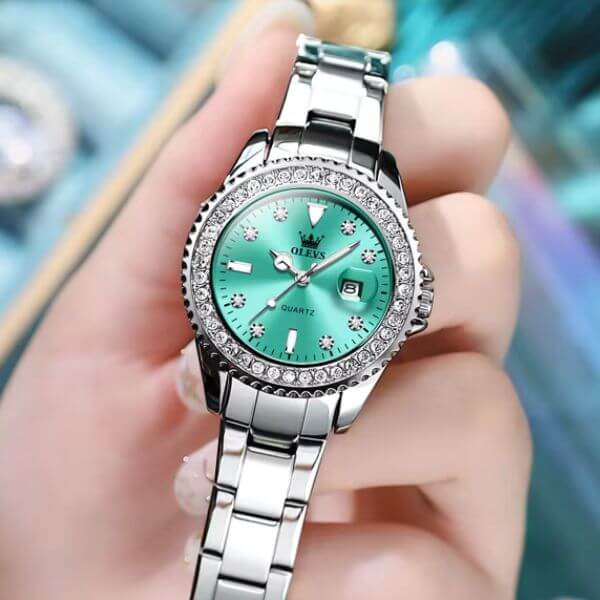 Montre femme Olevs Apolline à cadran vert tenue à la main