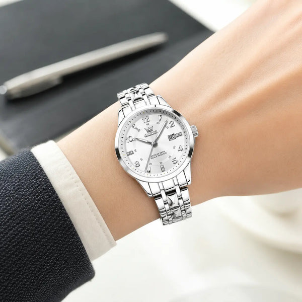 Montre femme OLEVS Valentine argentée portée au poignet, cadran clair et bracelet en acier